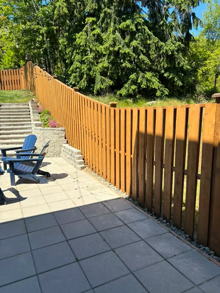 Finished patio fence line with even warm stain coverage