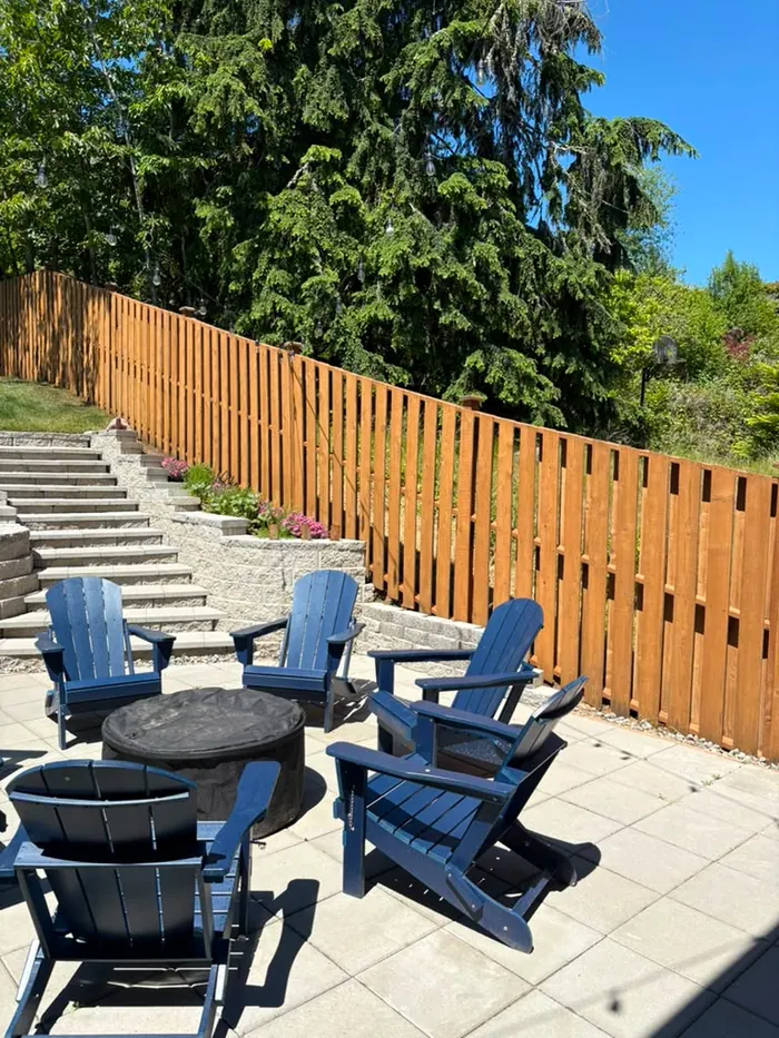 Finished stained fence beside patio steps and seating area