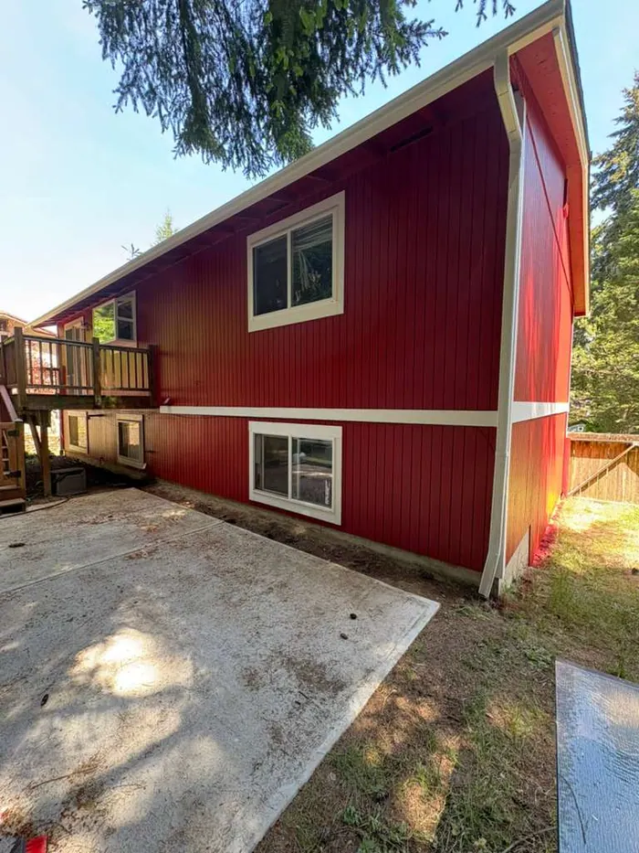 Finished red exterior repaint on driveway side of home
