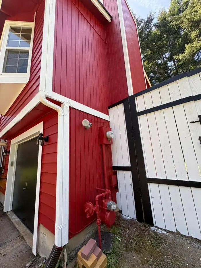 Finished entry door trim with red siding and light trim paint