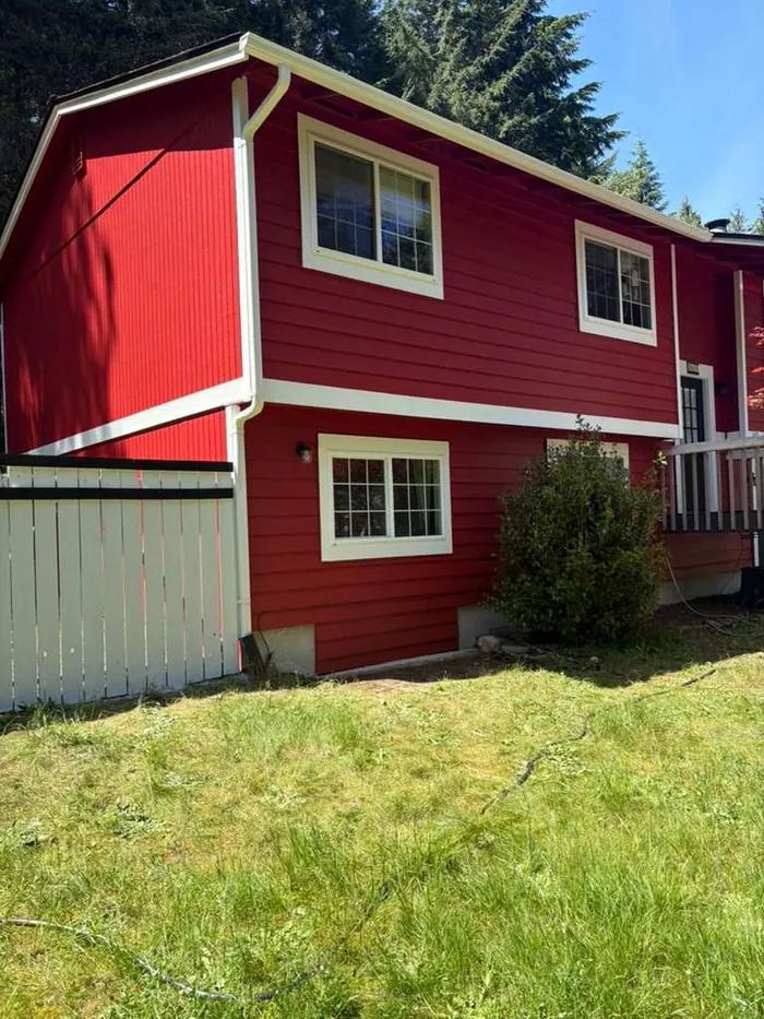 Finished red house exterior with white trim viewed from the yard
